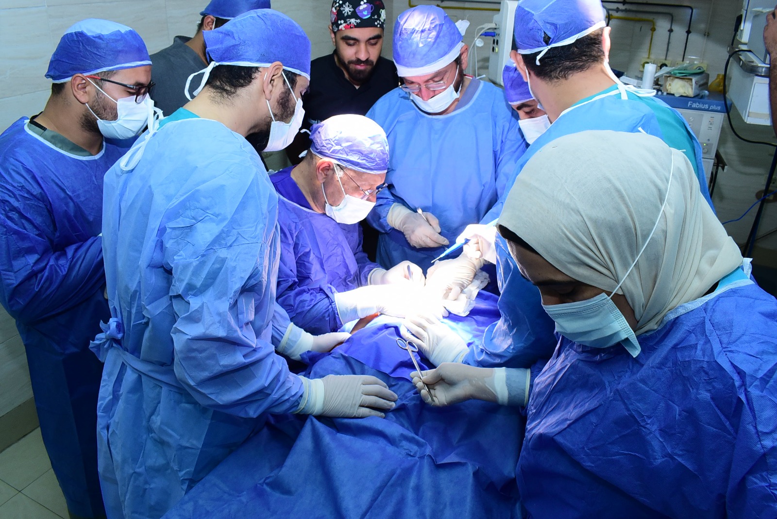 فريق طبي بوحدة الجراحات الميكروسكوبية بقيادة رئيس جامعة سوهاج يجري عملية جراحية لطفلة مصابة بشلل ولادي كامل